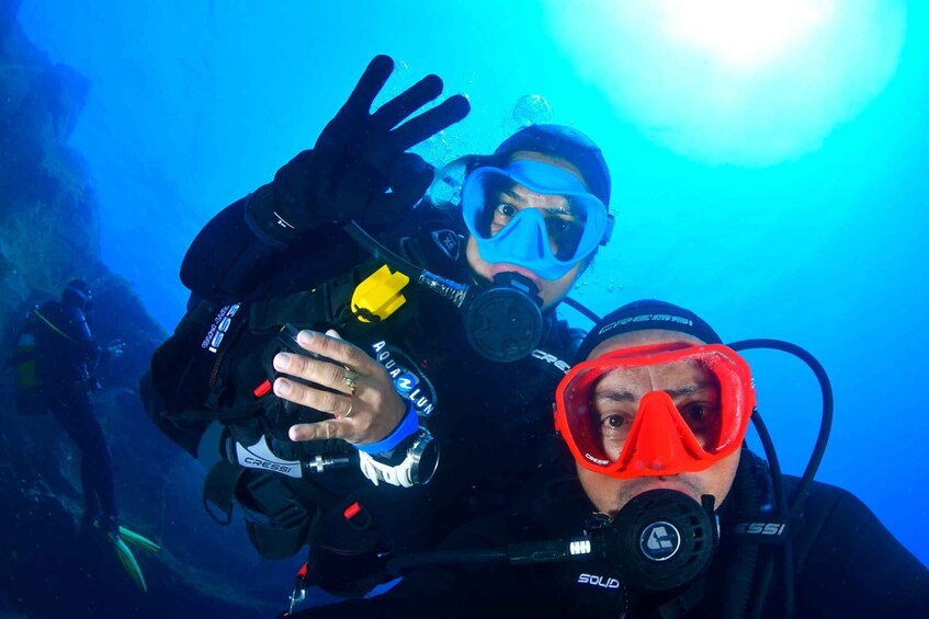 Two scuba divers underwater with their equipment. 3