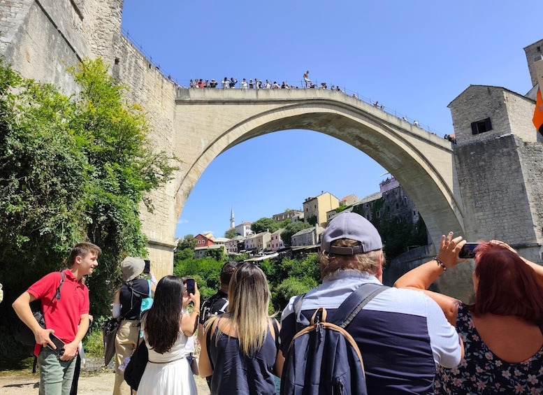 A stone bridge with tourists taking photos. 3