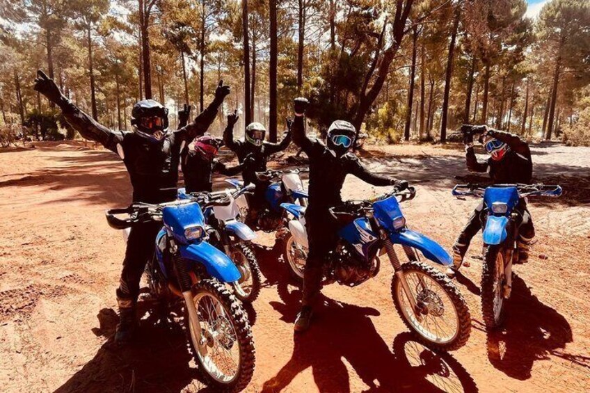 Four riders on blue dirt bikes in a forested area. 5