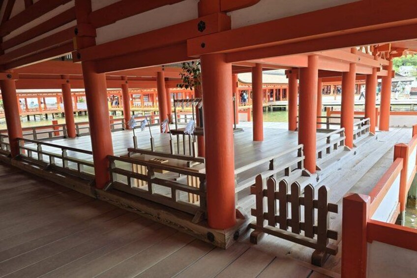 A traditional Japanese structure with red pillars and wooden flooring. 5