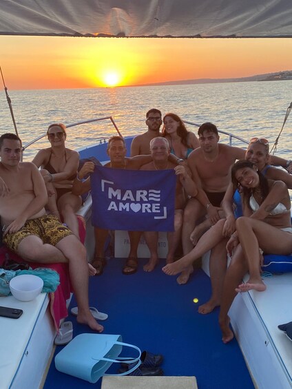 A group of people on a boat at sunset. 5
