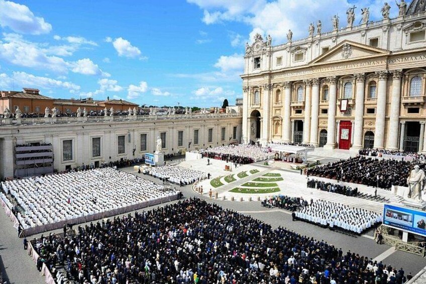 A large crowd gathered in a square in front of a grand building with columns and statues. 3
