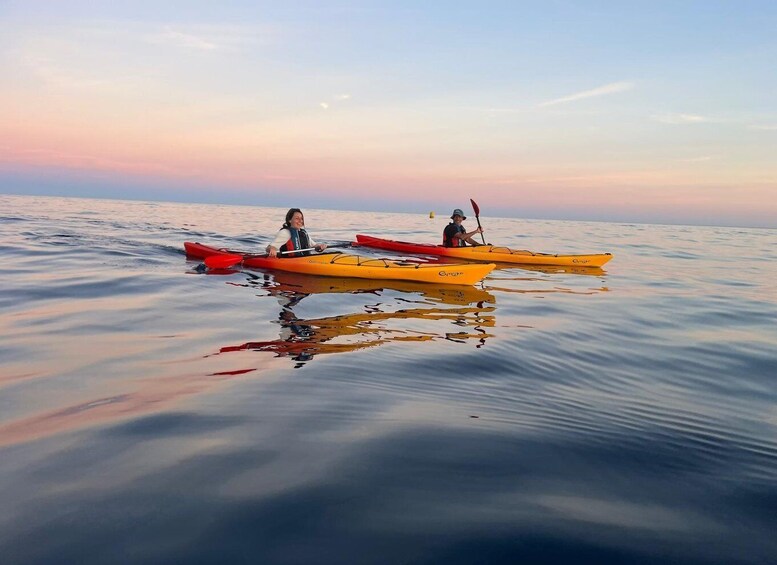 Two kayaks on calm water with a sunset sky. 3