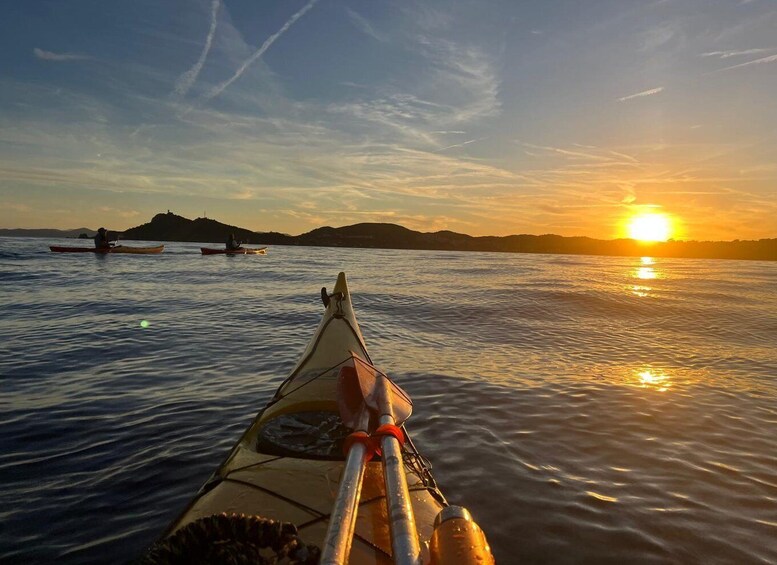 A kayak on calm water with a sunset in the background. 1
