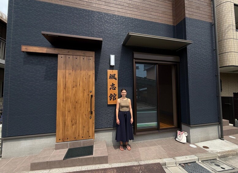 A building with a wooden door and a sign with Japanese characters. 4