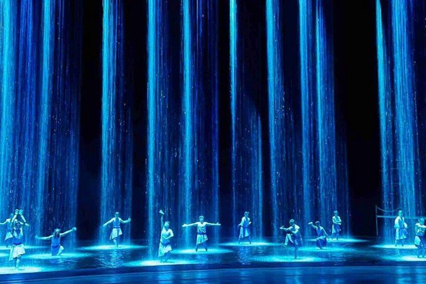 A water fountain with multiple jets of water, illuminated by blue lighting. 5