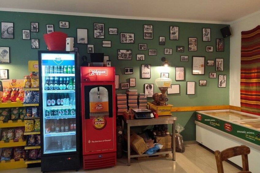 A room with a vending machine, a refrigerator, and a wall decorated with pictures. 4