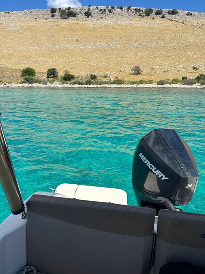 A boat with a Mercury outboard motor on clear turquoise water. 2