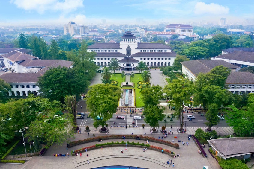 A large, white building with a central courtyard surrounded by trees and a fountain. 2