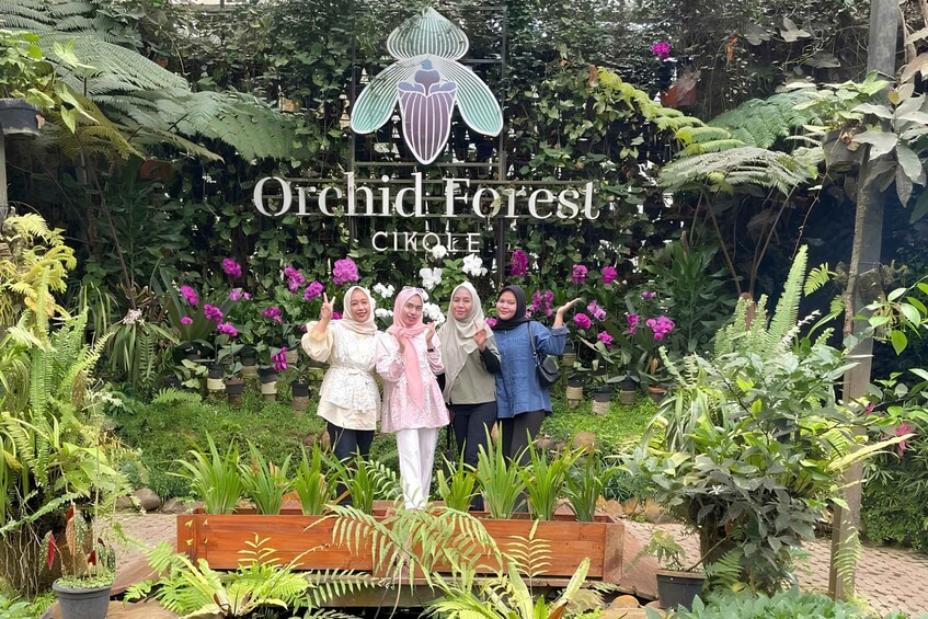 A group of people standing in front of a sign that reads 'Orchid Forest Circle.' 2