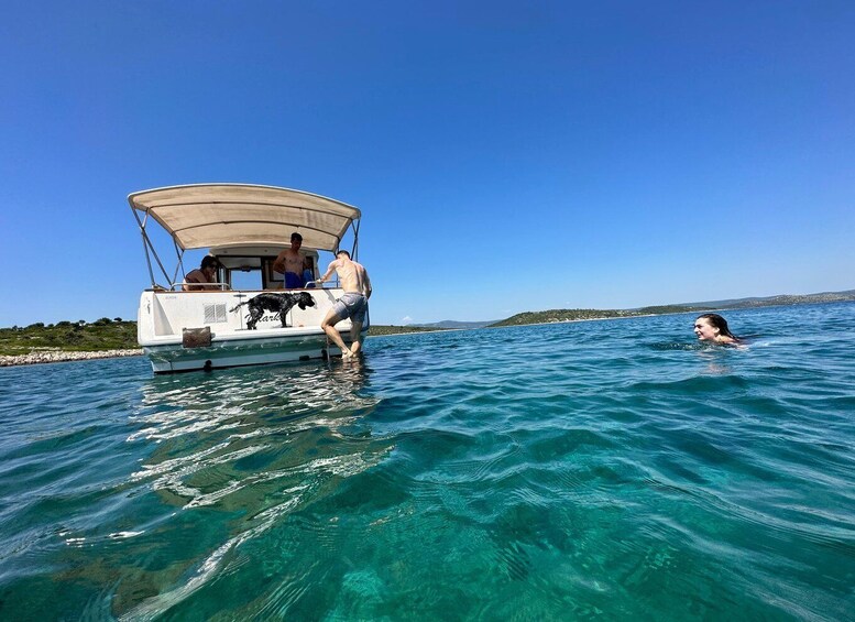 A boat with people and a dog on a clear day. 5