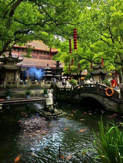 A traditional Chinese garden with a stone bridge, a pond with koi fish, and a pagoda. 2