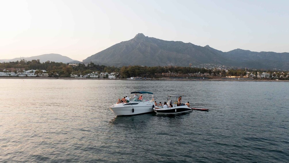 Two boats on calm water with a mountainous backdrop. 3