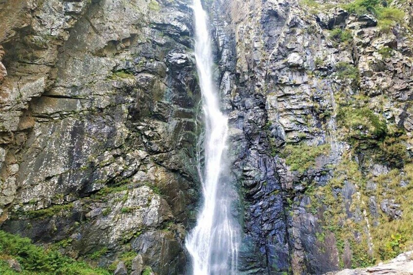 A waterfall cascading down a rocky cliff. 1