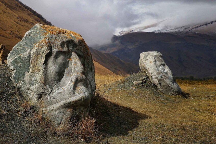 Two large stone carvings in a mountainous landscape. 2