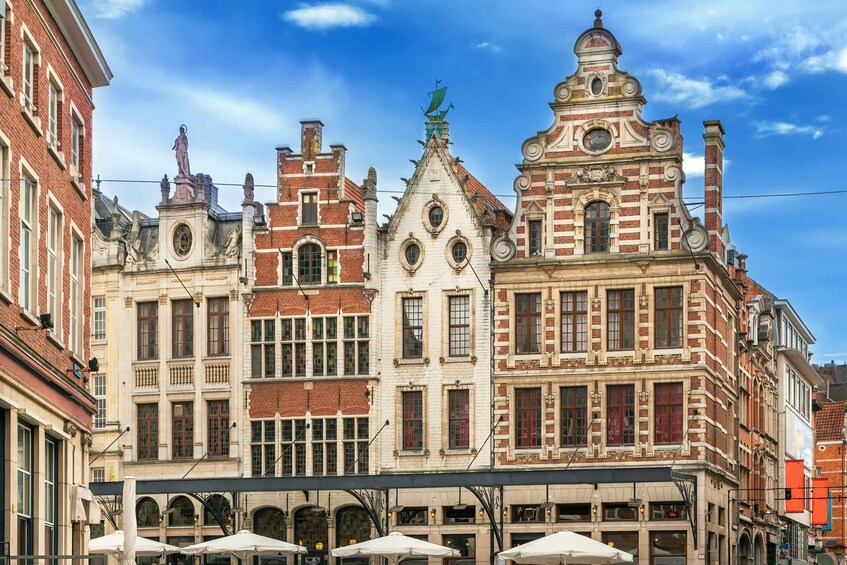A row of historic European-style buildings with ornate facades and a clear blue sky. 3