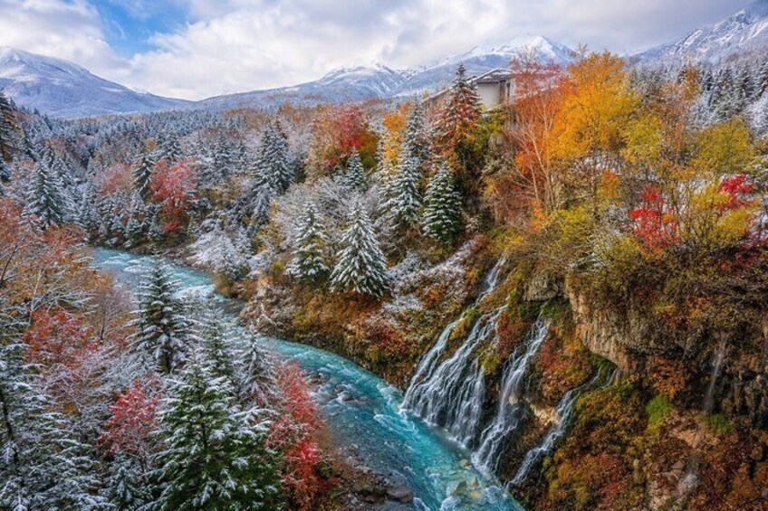 A river winding through a forested valley with autumn foliage and a waterfall. 3
