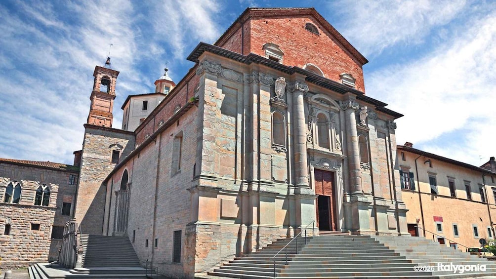 A historic church with a bell tower and a staircase leading to the entrance. 2