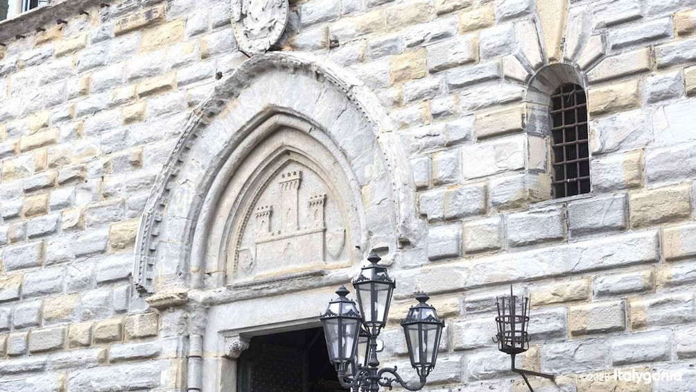A stone building with a pointed arch window and a decorative lantern. 3