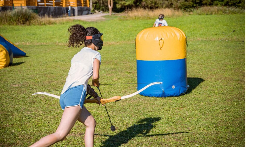 A person playing archery in an outdoor setting. 3