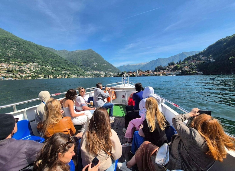 A group of people on a boat with a mountainous landscape in the background. 5