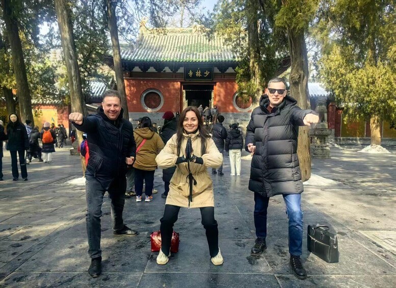 A group of people in front of a traditional building with a green roof and red walls. 5