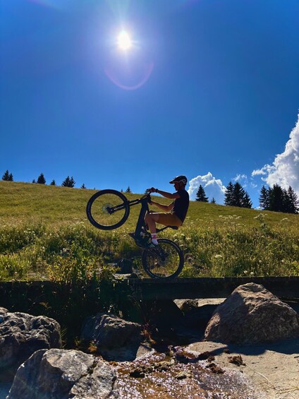A person on a mountain bike performing a jump over rocks. 3