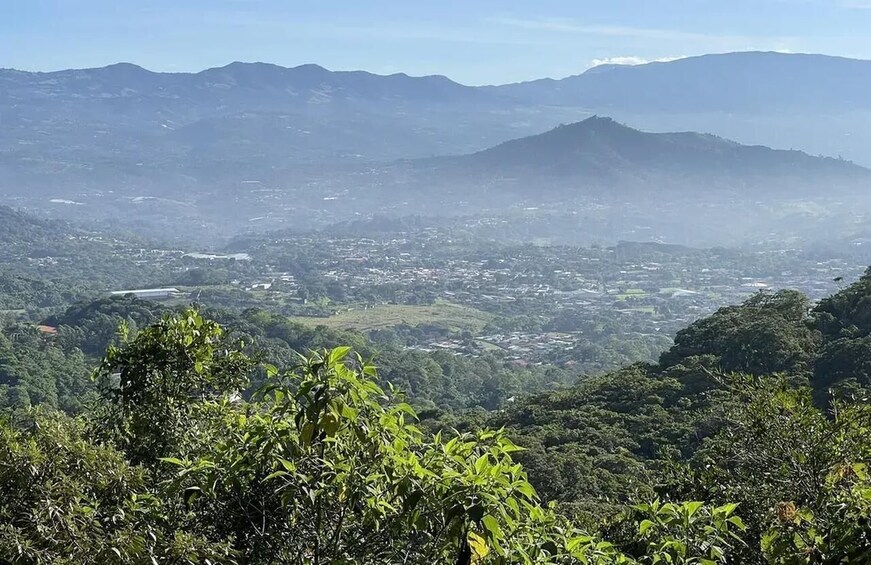 A mountainous landscape with a valley and a town in the distance. 3