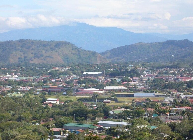 A town nestled in a valley with mountains in the background. 2