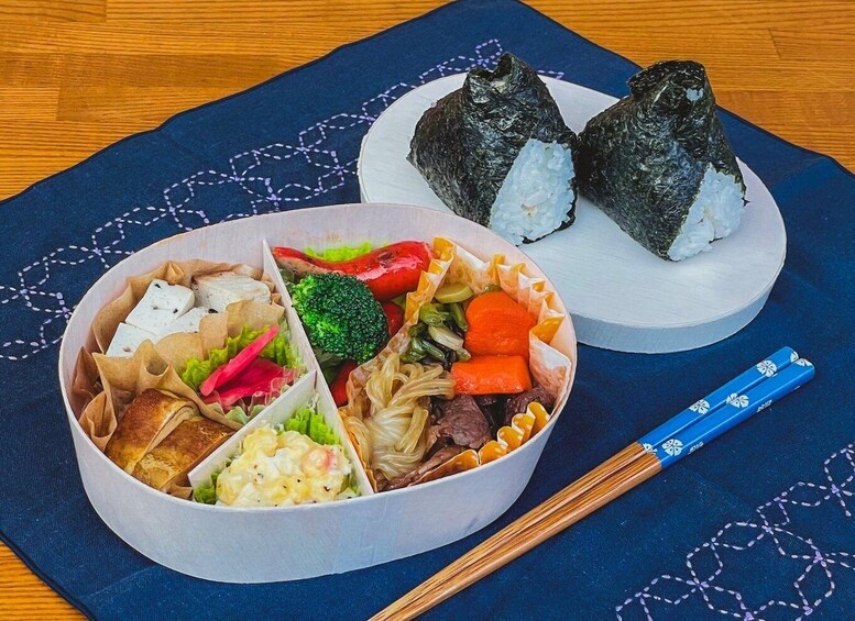 A meal with sushi, tofu, vegetables, and a bowl of salad. 4
