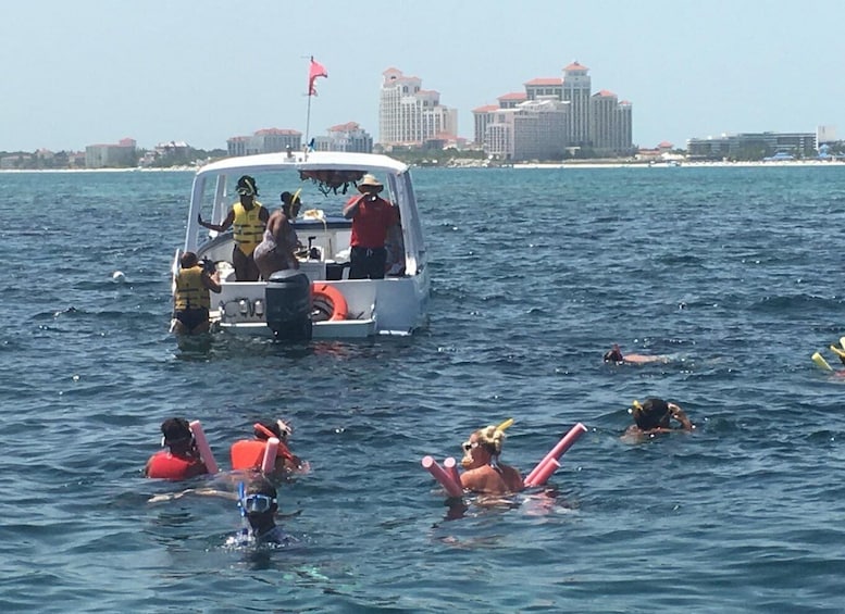 A boat with people on board and swimmers in the water. 4