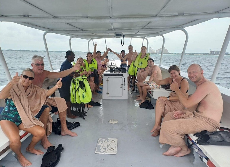 A group of people on a boat, some giving thumbs up, with a city skyline in the background. 3