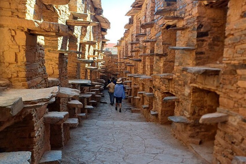 A narrow stone pathway flanked by ancient brick structures. 5