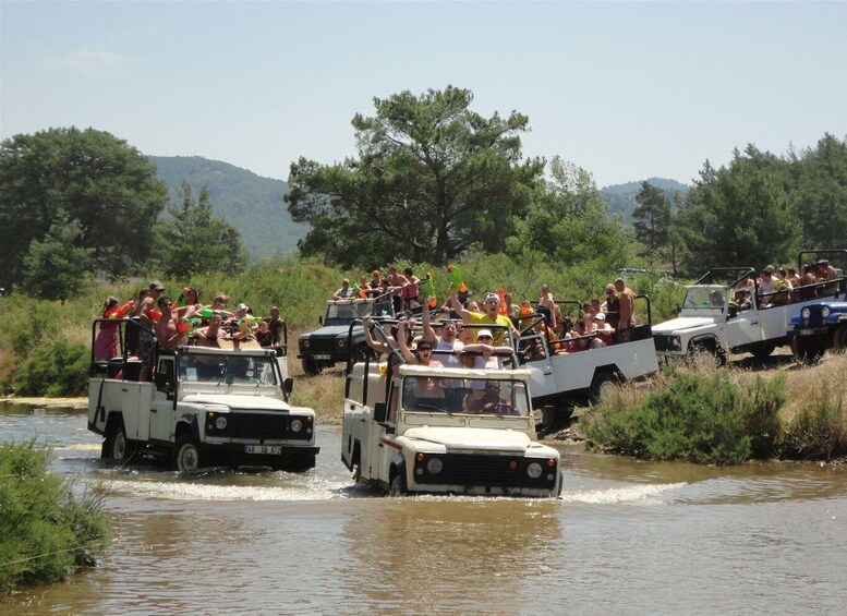 A group of people on vehicles driving through a shallow river. 5