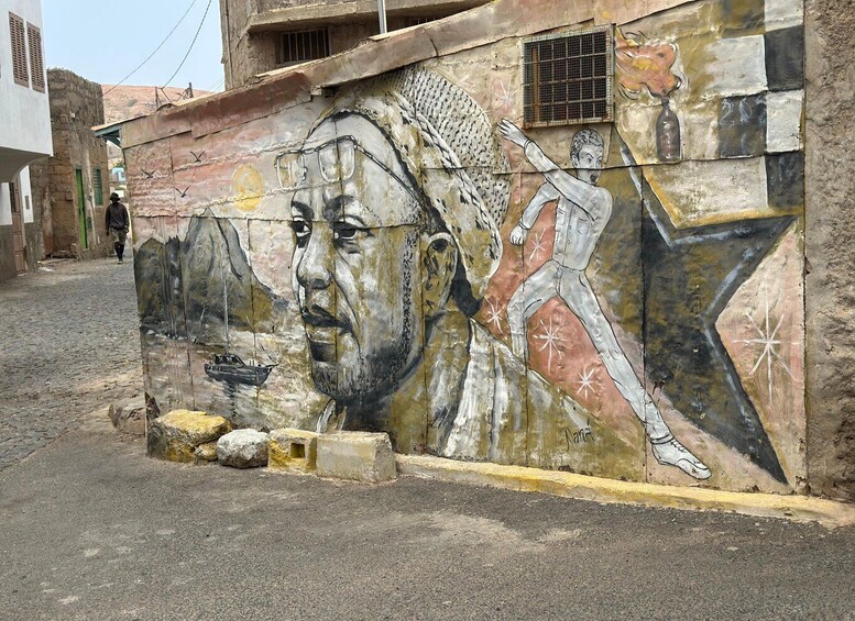 A mural on a building wall with a ship and abstract patterns. 5