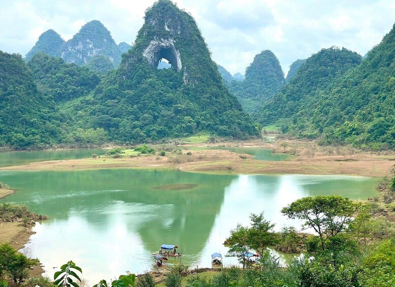 A lake surrounded by lush green hills with a prominent rock formation in the center. 5