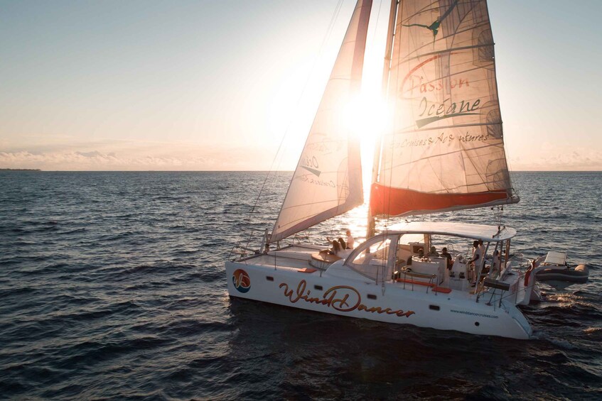 Ein Segelboot namens 'Wind Dancer' auf dem Ozean vor dem Hintergrund eines Sonnenuntergangs. 2