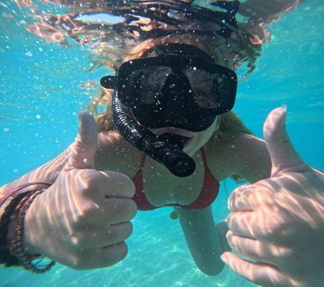 A person underwater giving a thumbs-up with snorkel gear. 1
