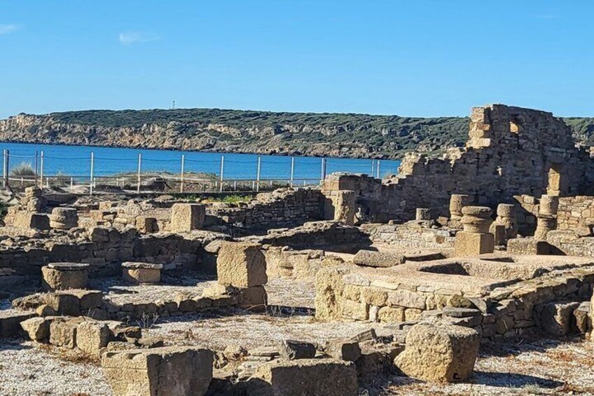 Ancient ruins by a coastal area with a clear blue sky. 3