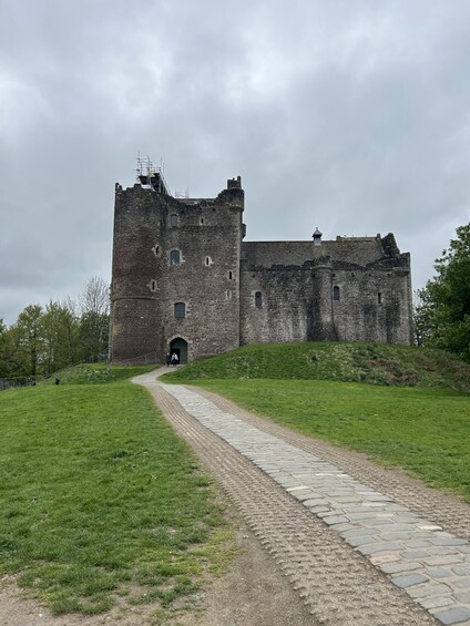 A historic castle with a stone pathway leading to its entrance. 2