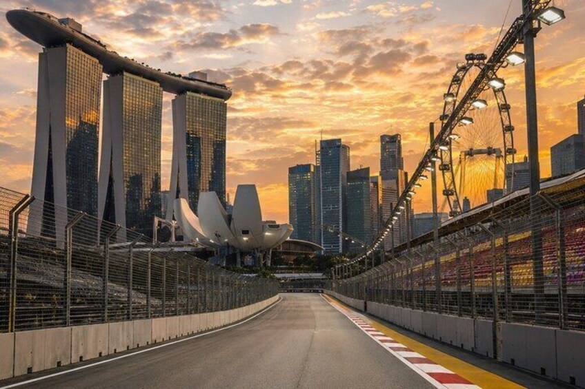 A road leading to a cityscape with modern buildings and a Ferris wheel. 1
