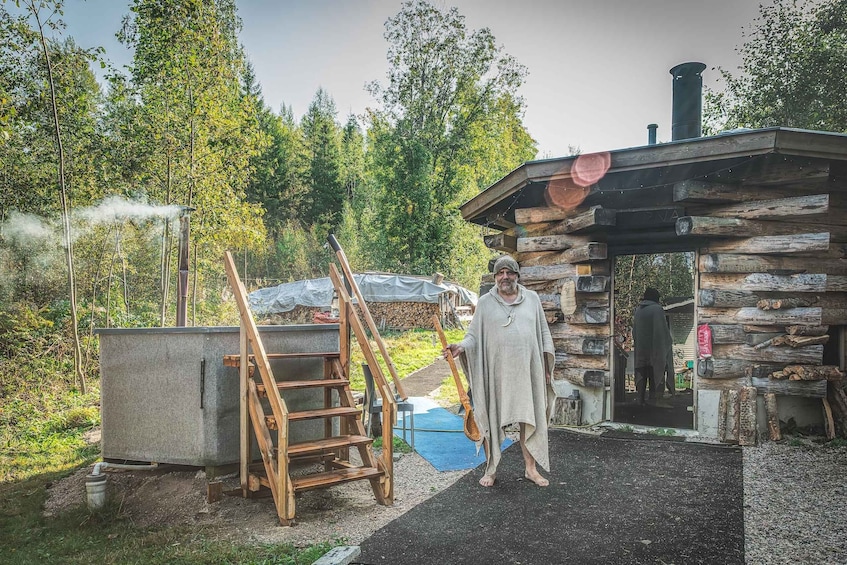 A rustic cabin with a chimney, surrounded by trees and a wooden ladder. 3