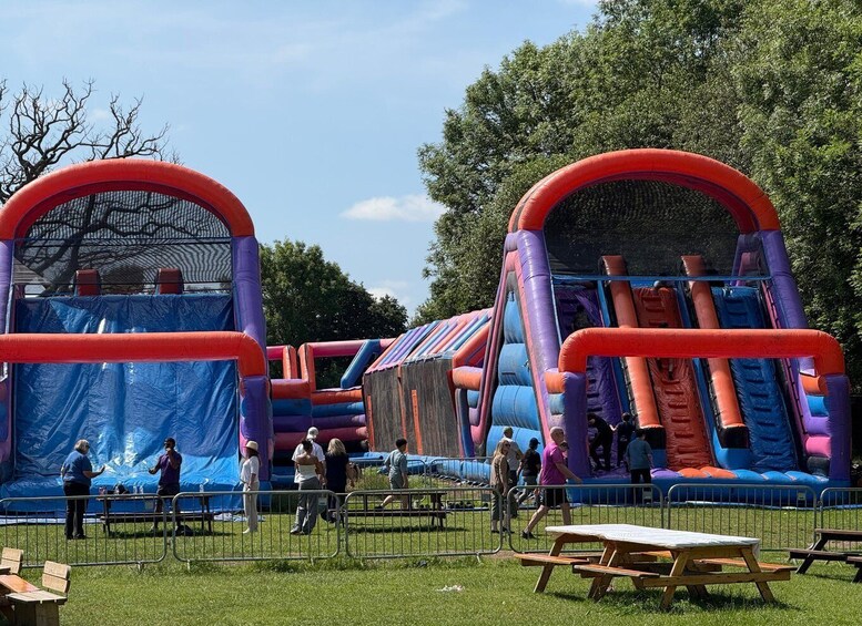 Inflatable bounce houses with slides and a netted area. 3