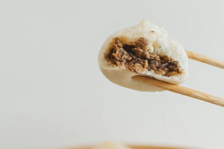 A food item, possibly a dumpling, held by chopsticks. 5
