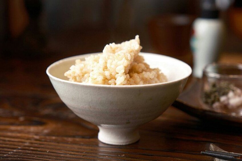 A bowl of rice on a wooden table. 2