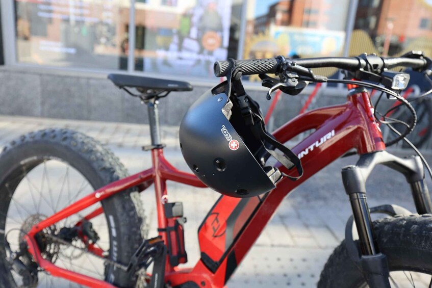 A red mountain bike with a black helmet attached to the frame. 3