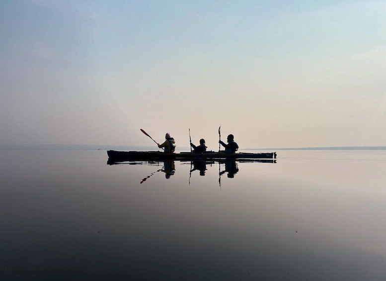 Two people canoeing on a calm lake with a clear sky. 5