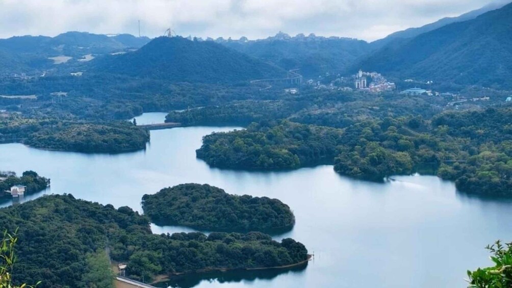 A lake surrounded by forested hills with a small island in the center. 1