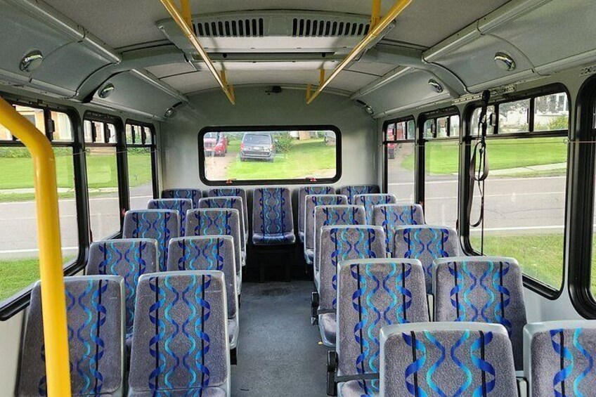 A bus interior with patterned seats and windows. 3