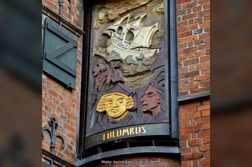 A building facade with a ship and masks, and the word 'CILUMBUS' on it. 4